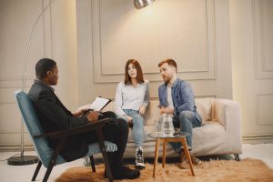A realtor meeting with a couple to discuss real estate options. Modern indoor setting with a casual atmosphere.